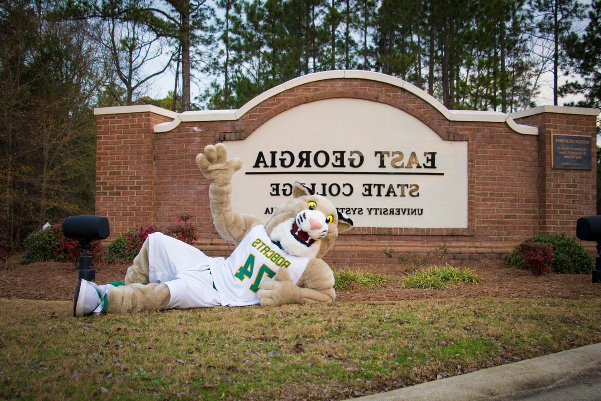 Bob the Bobcat in front of entrance sign